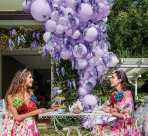 Lilac balloon arch with flowers for outdoor tea party, elegant balloon decoration for garden events