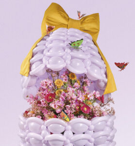 Lilac balloon art installation with oversized bow and floral base, designed for artistic displays and luxury decor.