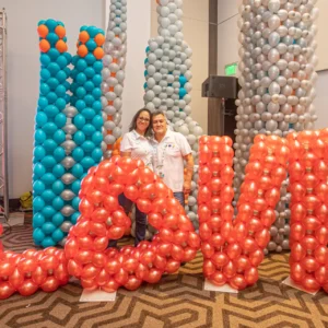 Giant balloon love letters in red with tall silver and blue balloon towers, creative balloon installation for large events