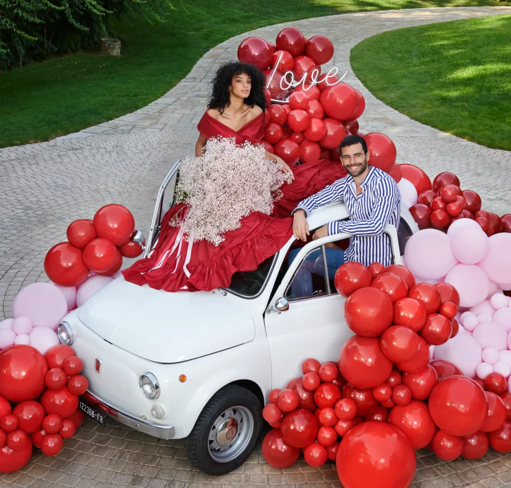 Romantic car balloon decoration with red and pink balloons, perfect for Valentine’s Day proposals or wedding celebrations