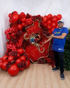 A vibrant red Balloon Murals serving as a stunning backdrop for photos, made from meticulously arranged crimson and scarlet balloons of different sizes.