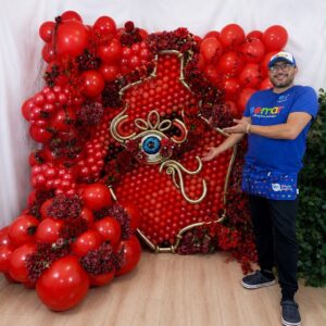 A vibrant red Balloon Murals serving as a stunning backdrop for photos, made from meticulously arranged crimson and scarlet balloons of different sizes.